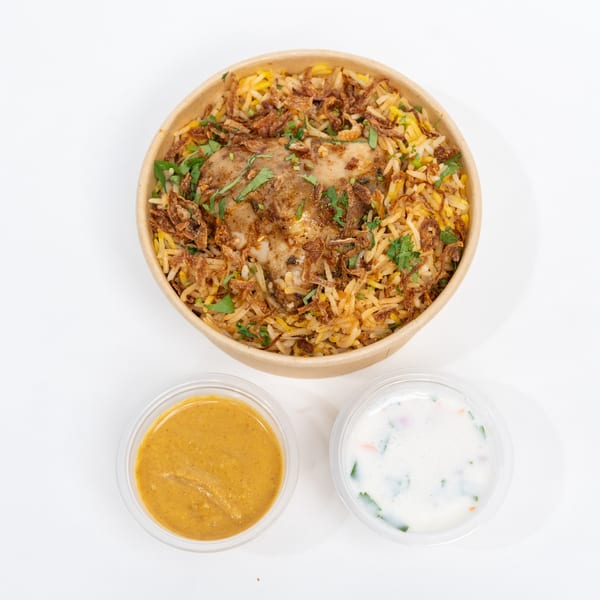H1B Hyderabad No1 Biryani chicken biryani with fried onions, cilantro, and two sauces.