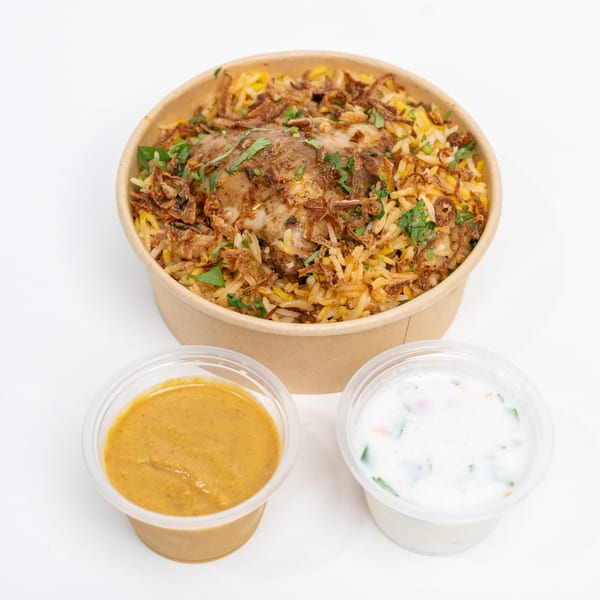 H1B Hyderabad No1 Biryani chicken biryani in a bowl with two side sauces.